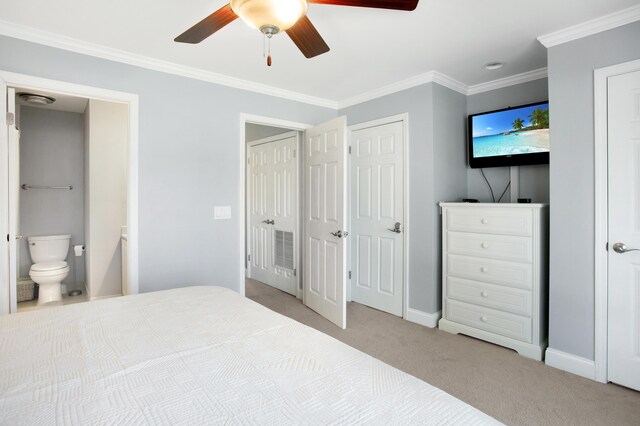 bedroom featuring two closets, light colored carpet, ceiling fan, crown molding, and connected bathroom