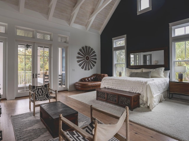 bedroom with high vaulted ceiling, multiple windows, access to outside, and french doors