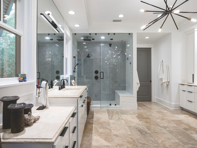 bathroom with a notable chandelier, a shower with shower door, and vanity