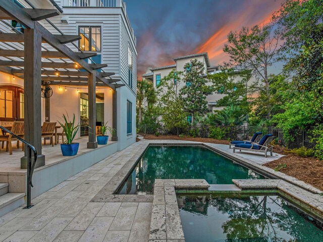 pool at dusk with an in ground hot tub, a pergola, and a patio