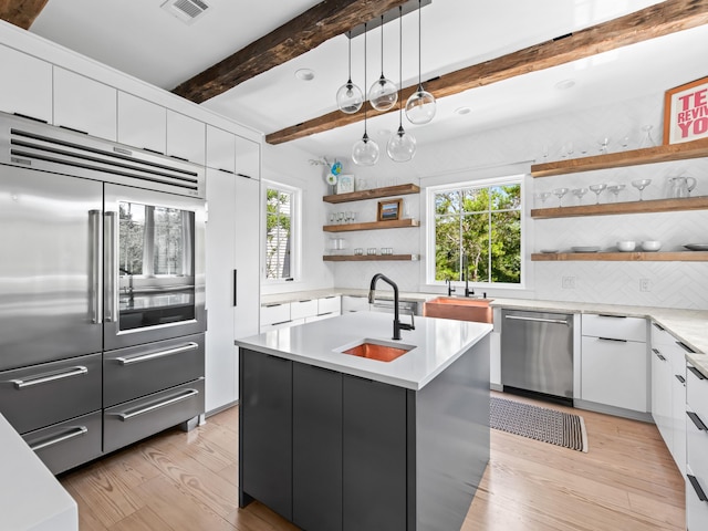 107 E Bermuda Dr, Santa Rosa Beach, FL 32459 - kitchen with appliances with stainless steel finishes, open shelves, light wood-type flooring, backsplash, and white cabinets