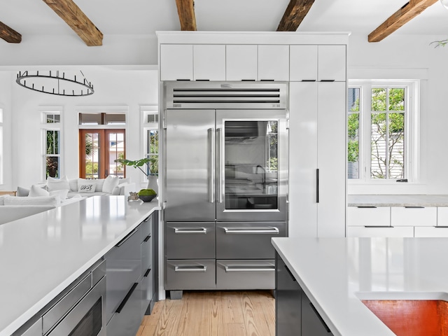 107 E Bermuda Dr, Santa Rosa Beach, FL 32459 - kitchen with stainless steel built in fridge, light countertops, beam ceiling, light wood-style floors, and gray cabinets