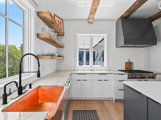 107 E Bermuda Dr, Santa Rosa Beach, FL 32459 - kitchen with wall chimney range hood, beam ceiling, backsplash, open shelves, and light countertops