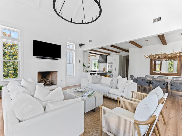 107 E Bermuda Dr, Santa Rosa Beach, FL 32459 - living area with beam ceiling, light wood finished floors, a fireplace, and a high ceiling