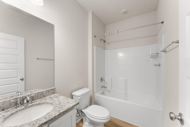 full bathroom with hardwood / wood-style floors, vanity, toilet, and shower / washtub combination