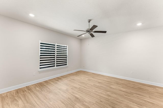 empty room featuring ceiling fan and light hardwood / wood-style flooring