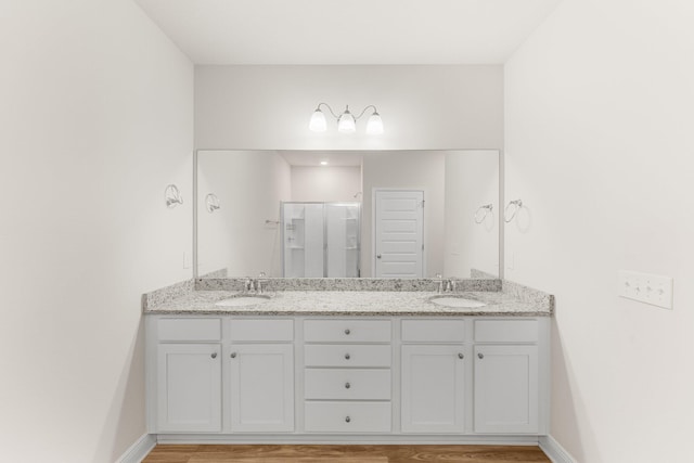 bathroom featuring vanity, hardwood / wood-style flooring, and a shower with door