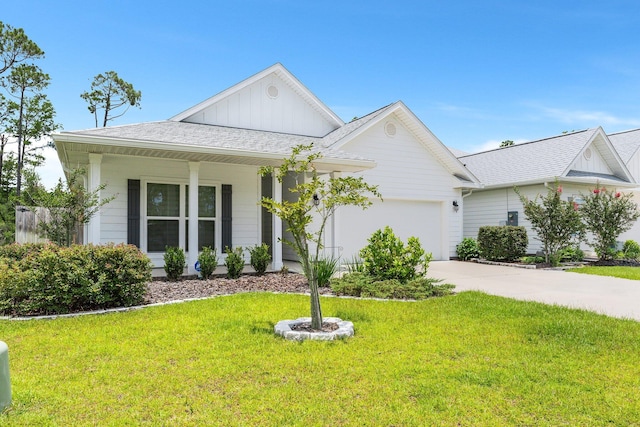 view of front of property with covered porch, a garage, and a front lawn