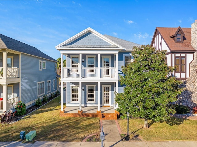 view of front of home featuring a balcony, a front yard, and covered porch