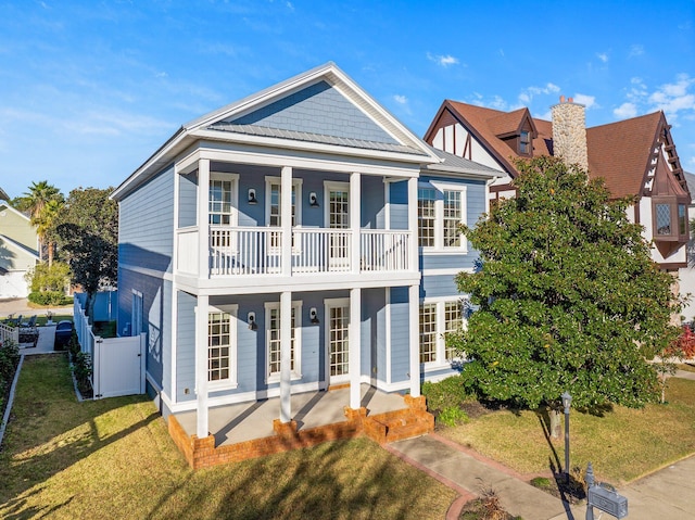 view of front facade featuring a balcony, a porch, and a front lawn