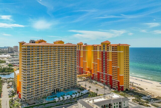 view of building exterior with a water view and a view of the beach