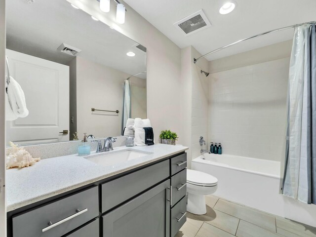 full bathroom featuring toilet, vanity, tile patterned floors, and shower / bathtub combination with curtain