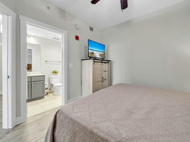 bedroom featuring ensuite bath, ceiling fan, and light hardwood / wood-style flooring