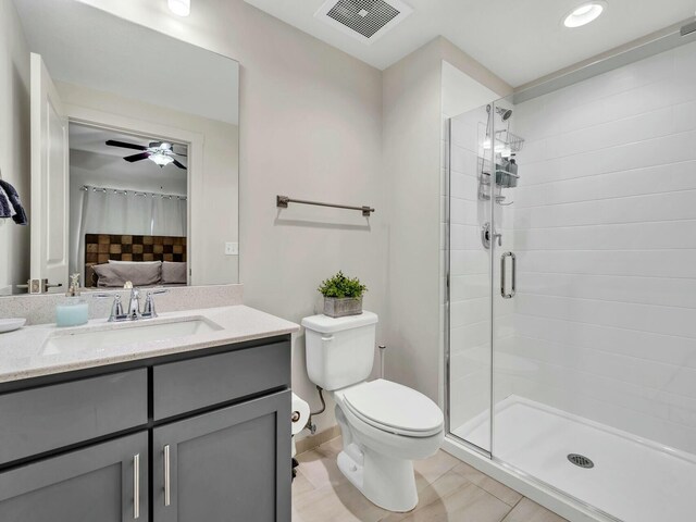 bathroom with walk in shower, vanity, ceiling fan, tile patterned flooring, and toilet