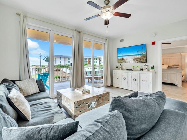 living room with light hardwood / wood-style flooring and ceiling fan