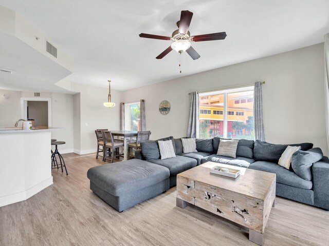 living room featuring ceiling fan and light hardwood / wood-style flooring