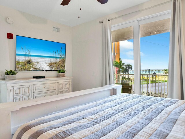 bedroom with access to outside, ceiling fan, and a water view