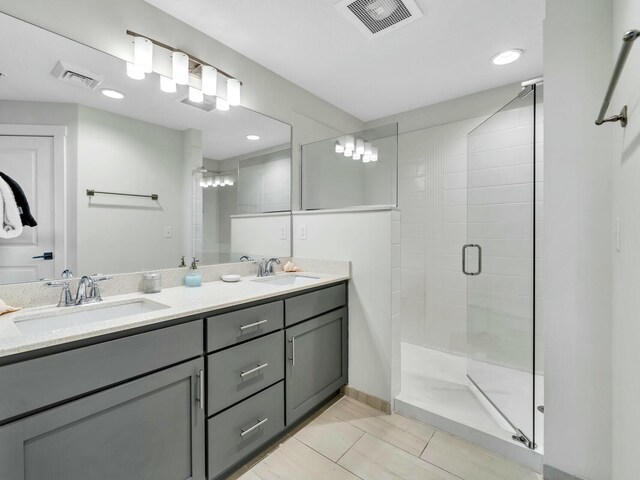 bathroom with tile patterned flooring, vanity, and walk in shower