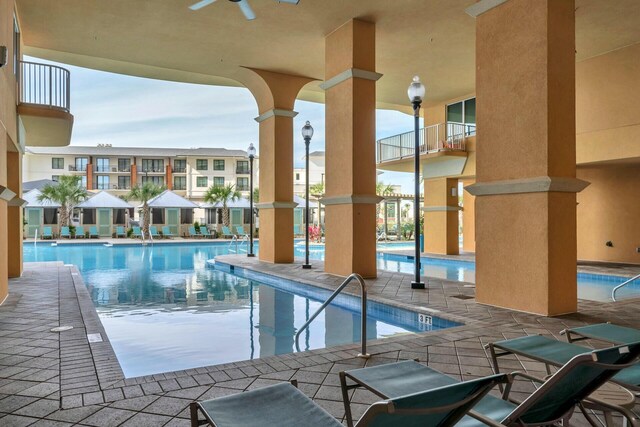 view of swimming pool featuring ceiling fan and a patio area