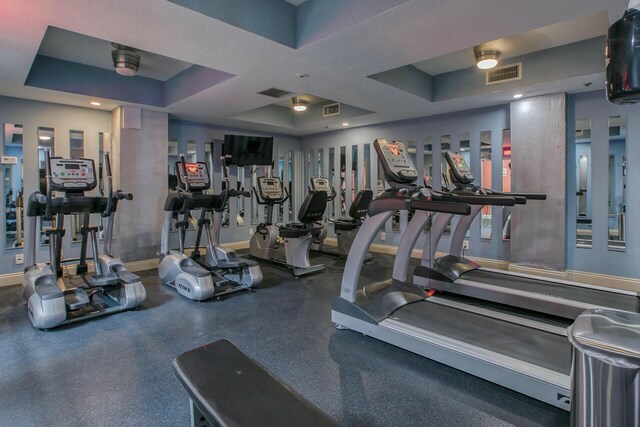 workout area with a tray ceiling