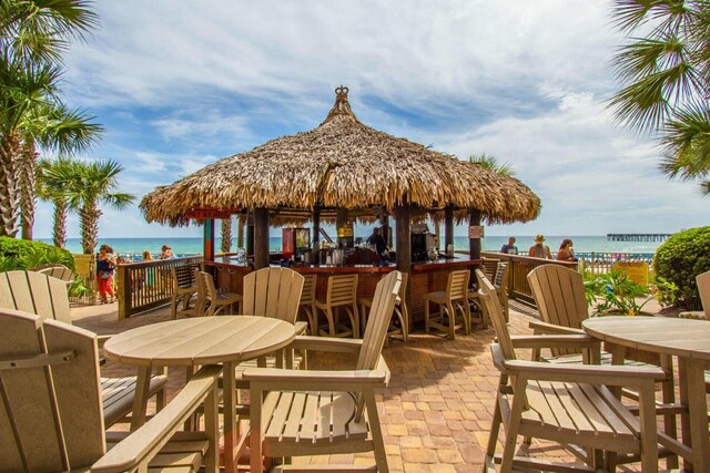 view of patio / terrace featuring a water view and a beach view