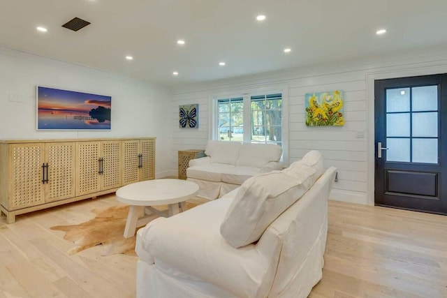 living room with light wood-type flooring, visible vents, and recessed lighting