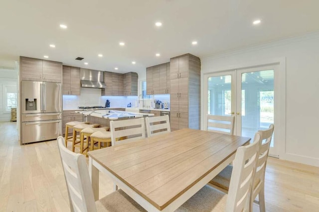 dining room with french doors, light wood finished floors, recessed lighting, and crown molding