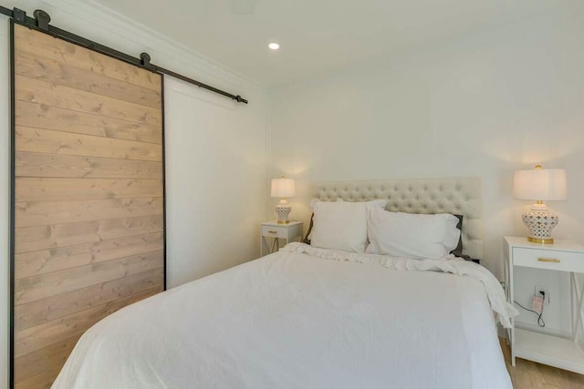 bedroom featuring a barn door and recessed lighting