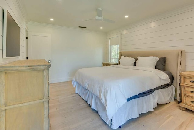 bedroom with light wood-style floors, baseboards, and crown molding