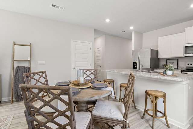 dining room featuring light hardwood / wood-style floors and sink