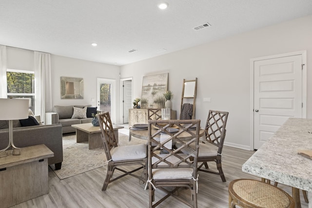 dining area featuring a textured ceiling and hardwood / wood-style flooring