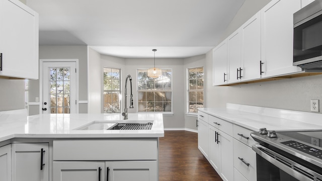 kitchen featuring stainless steel appliances, white cabinetry, hanging light fixtures, and sink