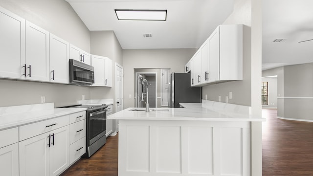 kitchen featuring light stone countertops, white cabinetry, stainless steel appliances, dark hardwood / wood-style flooring, and kitchen peninsula