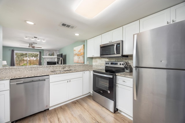 kitchen featuring white cabinets, backsplash, stainless steel appliances, and sink