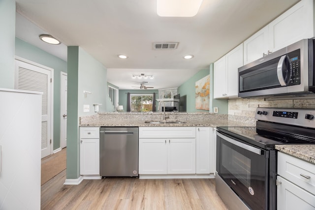 kitchen with white cabinetry, sink, ceiling fan, light hardwood / wood-style flooring, and appliances with stainless steel finishes