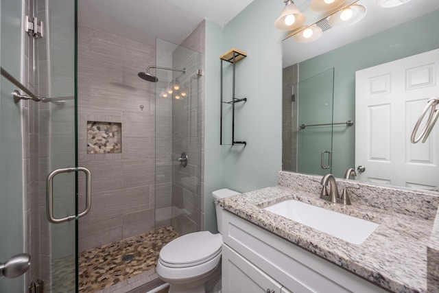 bathroom with vanity, toilet, and a shower with shower door