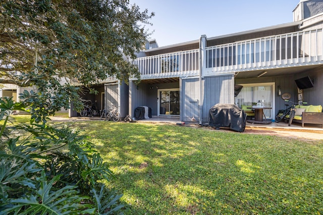 back of property with a lawn and a balcony