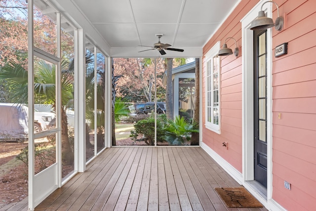 unfurnished sunroom with ceiling fan