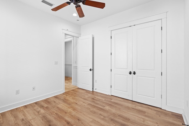 unfurnished bedroom featuring ceiling fan, light wood-type flooring, and a closet