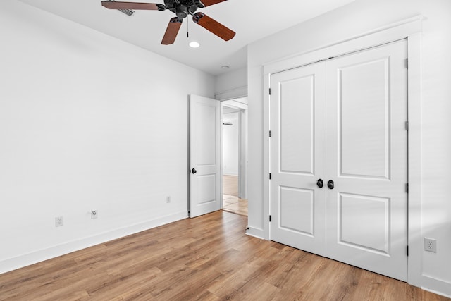 unfurnished bedroom featuring ceiling fan, light wood-type flooring, and a closet