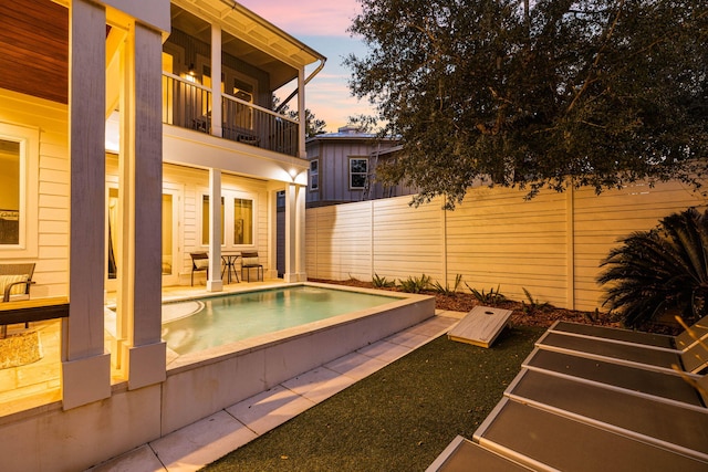 pool at dusk with a patio