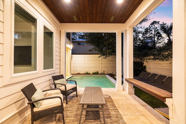 pool at dusk featuring a patio