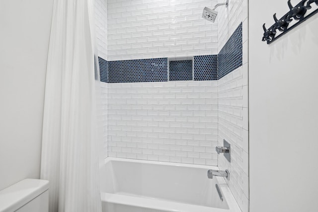 bathroom featuring shower / bathtub combination with curtain and toilet