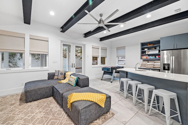 tiled living room with sink, beam ceiling, french doors, and ceiling fan