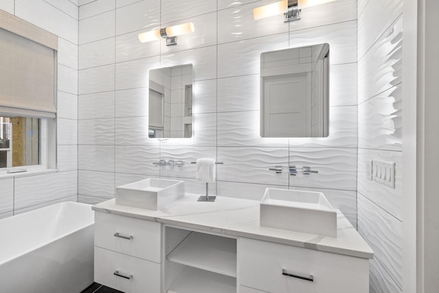 bathroom featuring a bath, vanity, and tile walls