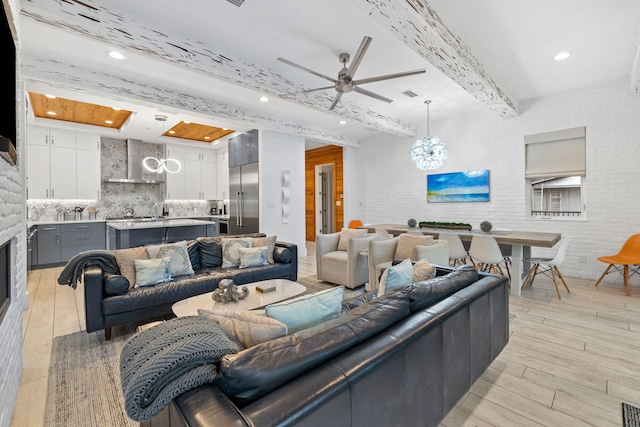 living room featuring beamed ceiling and ceiling fan