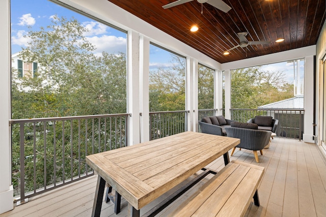 sunroom featuring a healthy amount of sunlight, wood ceiling, and ceiling fan