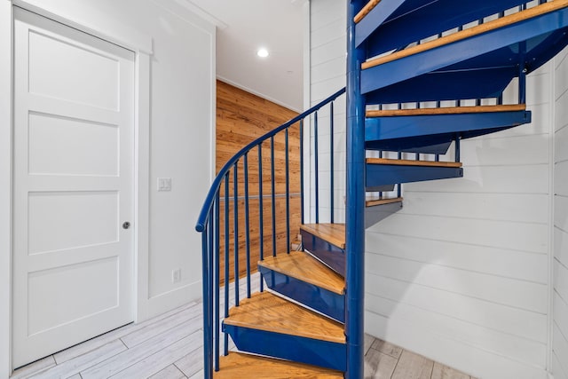 stairs featuring wood walls