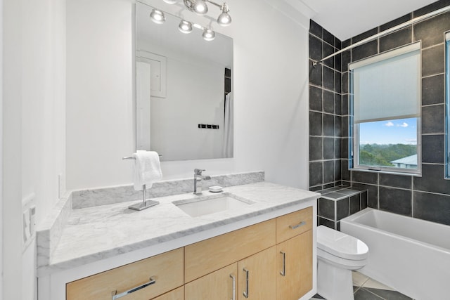 full bathroom featuring vanity, tiled shower / bath, tile patterned floors, and toilet