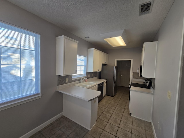 kitchen featuring kitchen peninsula, stainless steel appliances, sink, white cabinetry, and light tile patterned flooring